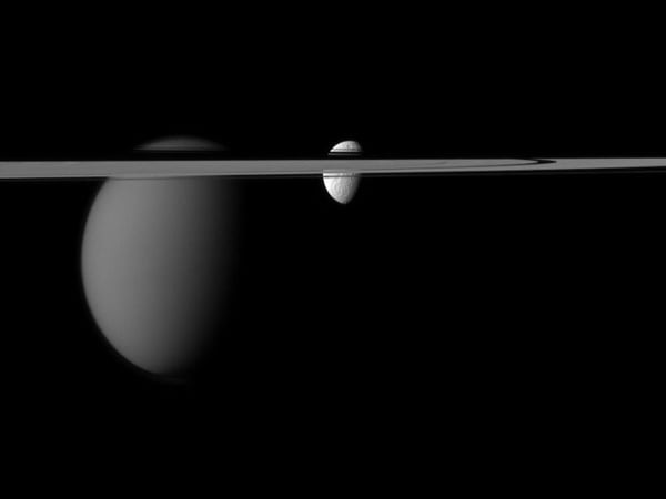 Saturn's rings with moons Titan and Thethys...epa03308420 A handout photo made available 16 July 2012 and produced by the Cassini-Huygens mission, a cooperative project of NASA, the European Space Agency and the Italian Space Agency, shows Saturn moons Titan (L) and Tethys as their view is disrupted by Saturn's rings. Cassini captured the view at a distance of approximately 1.4 million miles (2.2 million kilometers) from Tethys and 1.9 million miles (3.1 million kilometers) from Titan. EPA/NASA/JPL-Caltech/Space Science Institute EDITORIAL USE ONLY
